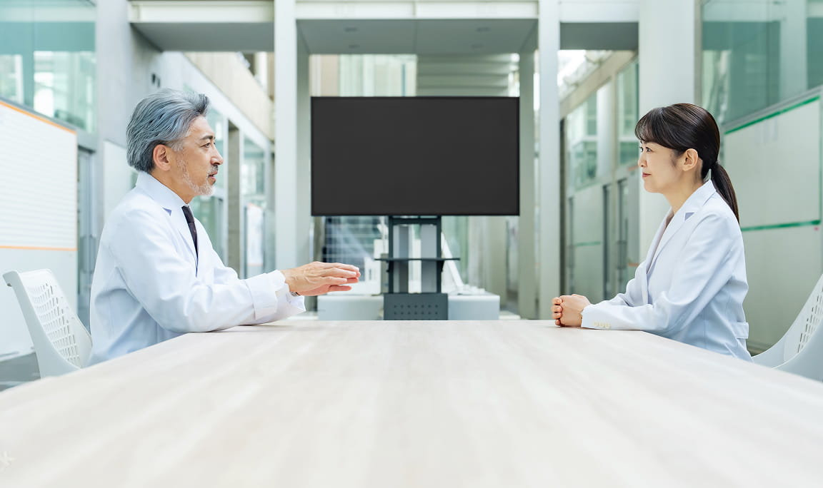 上司と部下が1対1の面談を行い、フィードバックや相談をしている様子